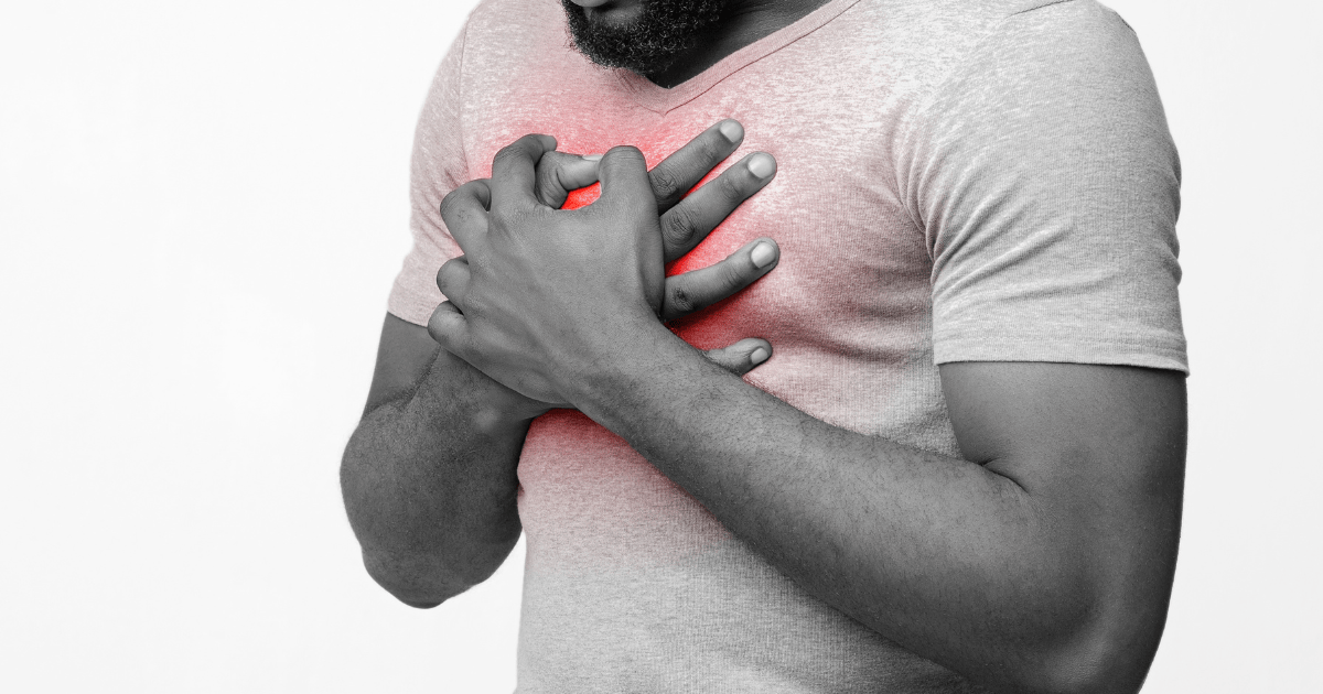 A man holding his chest due to heartburn